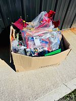 Overall view of cardboard box filled with loose LEGO and Mega Bloks pieces and sets