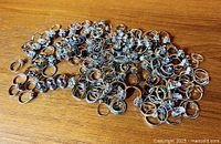 overview of large pile of assorted rings on wooden surface