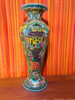 Full view of tall hand-painted vase showing overall form and artwork
