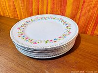 Stack of eight Paragon Anastasia dinner plates side view