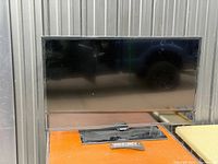 Front view of Samsung 40-inch TV on stand with remote