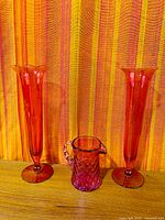 Overall shot of both ruby flash vases and cranberry pitcher