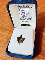 Pin in open Bond Boyd box showing branding and maple leaf design