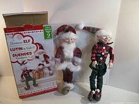 Box and two elf dolls standing in front