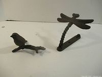 Bird figurine left, dragonfly door knocker right