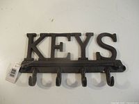 Front view of cast iron key holder showing KEYS lettering and five hooks