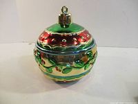 Closed cookie jar front view showing ornament shape and holly design