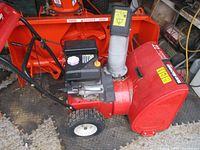 Left side view showing full snowblower, auger housing, engine, tires