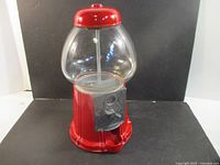 Front view of red 15" gumball machine showing globe, coin slot, base