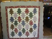Full view of patchwork pine tree quilt hanging