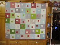 Full view of the 48 x 44 in patchwork quilt hanging