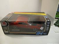 Front and side view of boxed New Bright Dodge Challenger R/C car