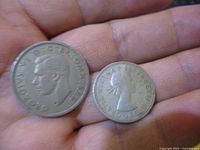 Obverse sides in hand showing George VI and Elizabeth II portraits