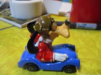 Side view of Goofy in blue Matchbox car