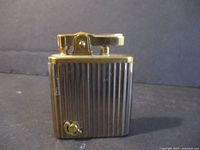 Front view of gold-tone ribbed musical lighter