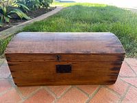 Front view showing wood grain, domed lid, lock plate