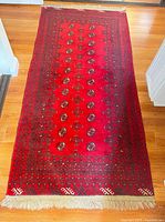 Full view of red Bokhara rug showing overall design and size