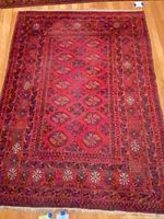 Full view of burgundy hand-knotted rug on floor