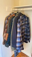 Seven wool jackets/overcoats hanging on rail, assorted plaid patterns and solids