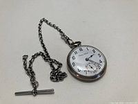 Front view of Elida pocket watch attached to sterling fob chain