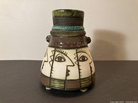 Full view of vase showing stylized faces and coloration