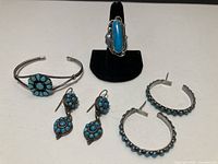 Group shot showing bracelet, ring on stand, dangle earrings and half-hoop earrings