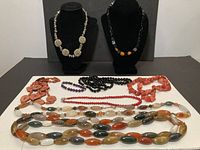 All ten jewellery pieces displayed including necklaces on stands and laid flat