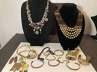 Full lot overview showing necklaces on busts and assortment of bracelets and earrings