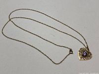 Full view of gold chain and heart pendant