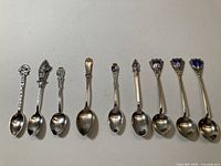 All nine sterling souvenir spoons lined up