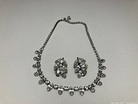 Earrings and necklace laid flat showing overall design