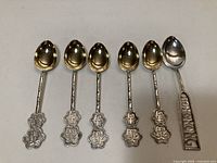 Front view of six silver teaspoons lined up