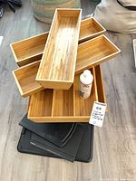 Stacked bamboo trays, plastic roller trays, UV3 polish bottle visible