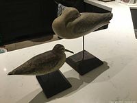 Both bird carvings on stands front view