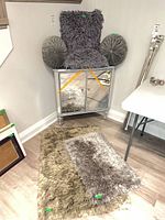 Overall view showing pillows stacked on cabinet and rug on floor