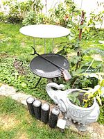 Both metal side tables and five solar stake lights in garden setting (elephant planter excluded)
