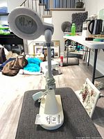 Lamp standing upright showing base, arm, head and cord