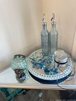 Group shot showing mirrored tray, two blue bottles, crystal lotus candle holder, glass turtle on LED base