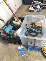 Tools grouped: Makita sander, teal jigsaw, Bosch blade packs, cords, hand tools, tool bag