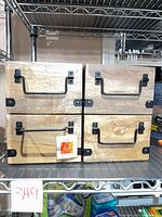 Front view of four hardwood storage boxes showing black metal handles and corner brackets