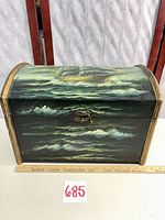 Front view showing painted waves, ship scene, latch, ruler for scale