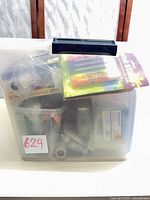 Closed clear plastic tote showing contents and sealed glitter glue pack on top