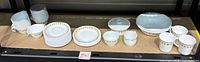 Entire set lined on shelf showing cups, saucers, plates, bowls, mugs