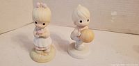Front view of both Precious Moments figurines
