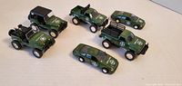Six green toy military vehicles arranged together