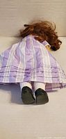Doll face down showing hair length, back of travel gown, socks, shoes