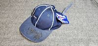 Full view of navy Reebok mesh cap showing autograph on brim and attached tag