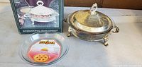 Box, lidded silver server, glass pie plate displayed together