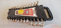 Full view of 12-piece wrench set in holder showing rust and label