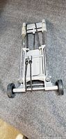 Hand truck folded flat showing wheels and base plate